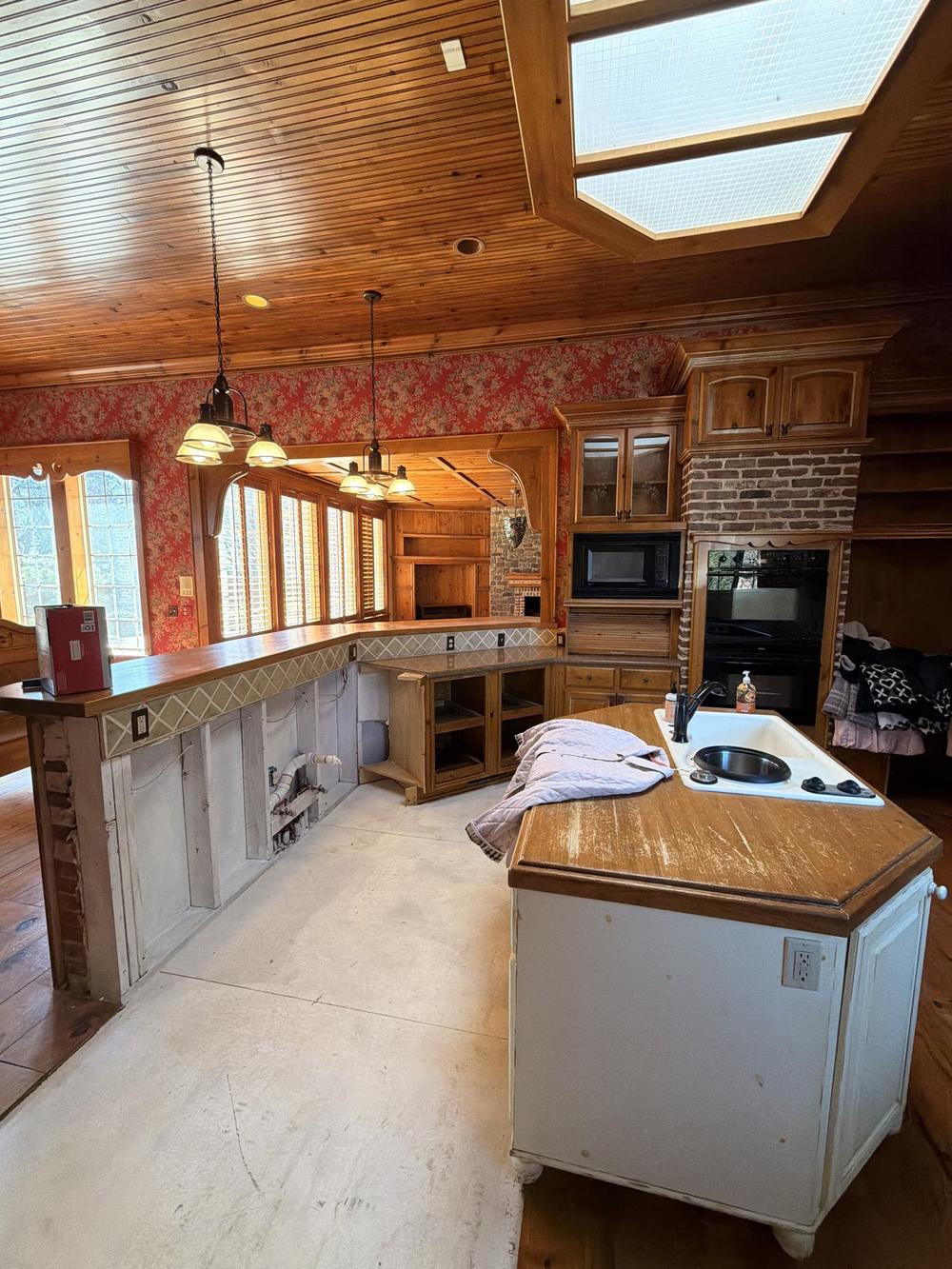 Windrush kitchen before renovation, with wood ceiling and skylight